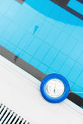 Pool thermometer at the edge of a swimming pool