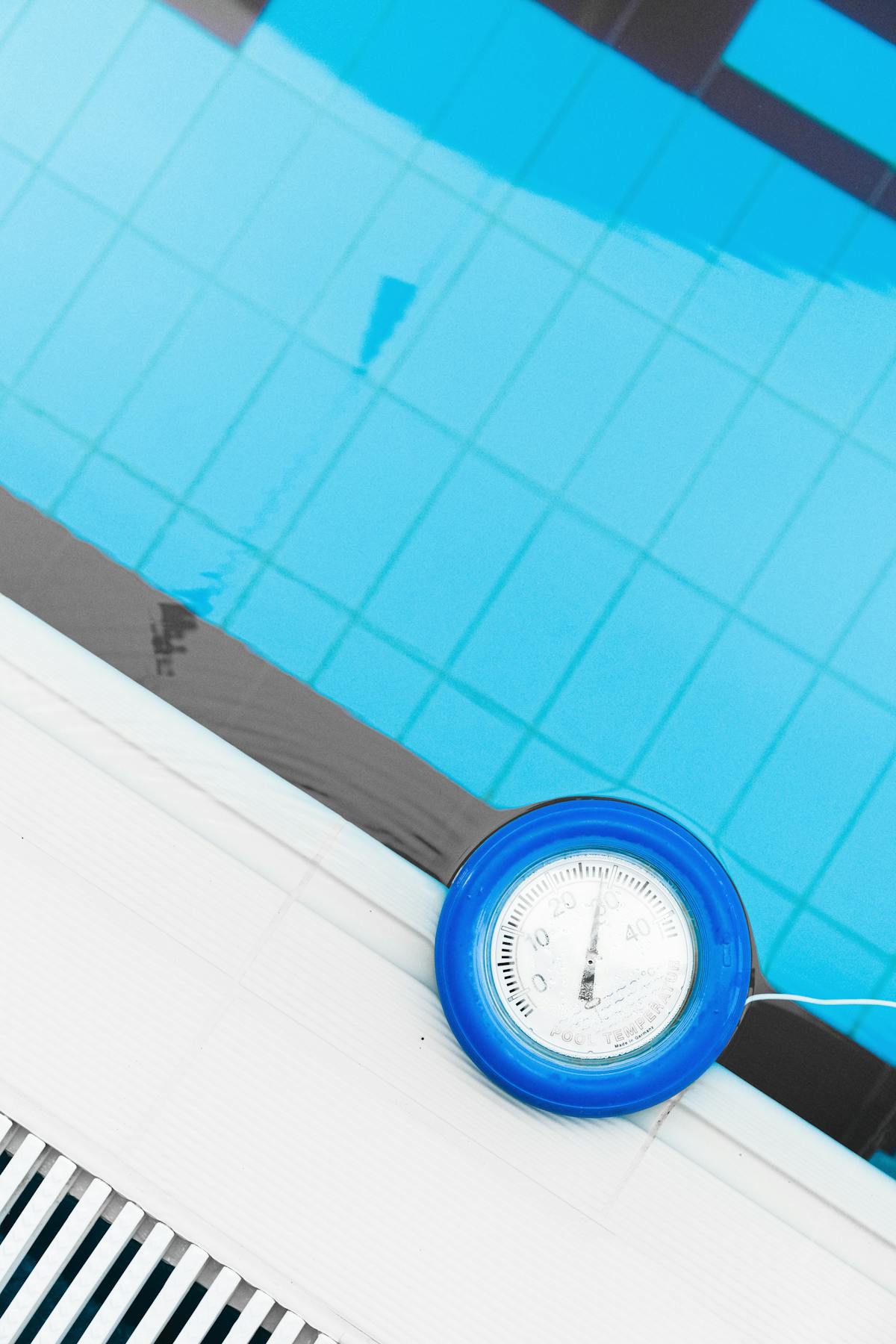 Pool thermometer at the edge of a swimming pool